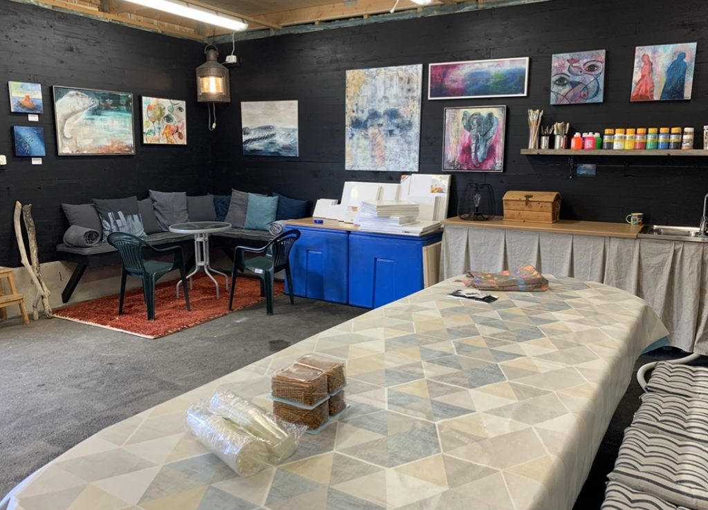 Atelje med arbetsbord, soffhörn och materialhylla